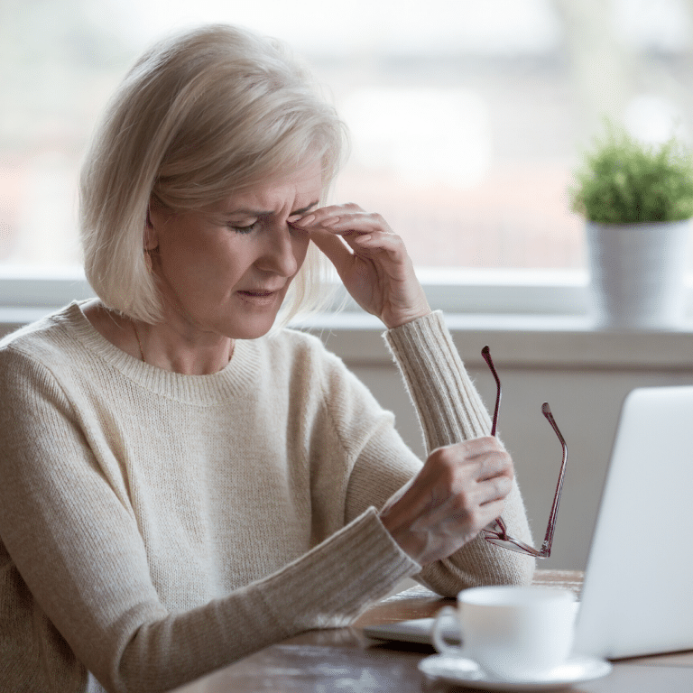 Mujer frente a un ordenador mostrando síntomas de fatiga visual